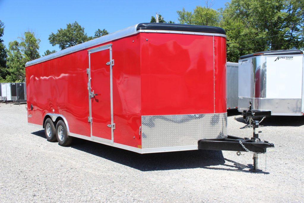 A bright red Stealth 8x20 enclosed cargo trailer on the Country Blacksmith dealership lot. 